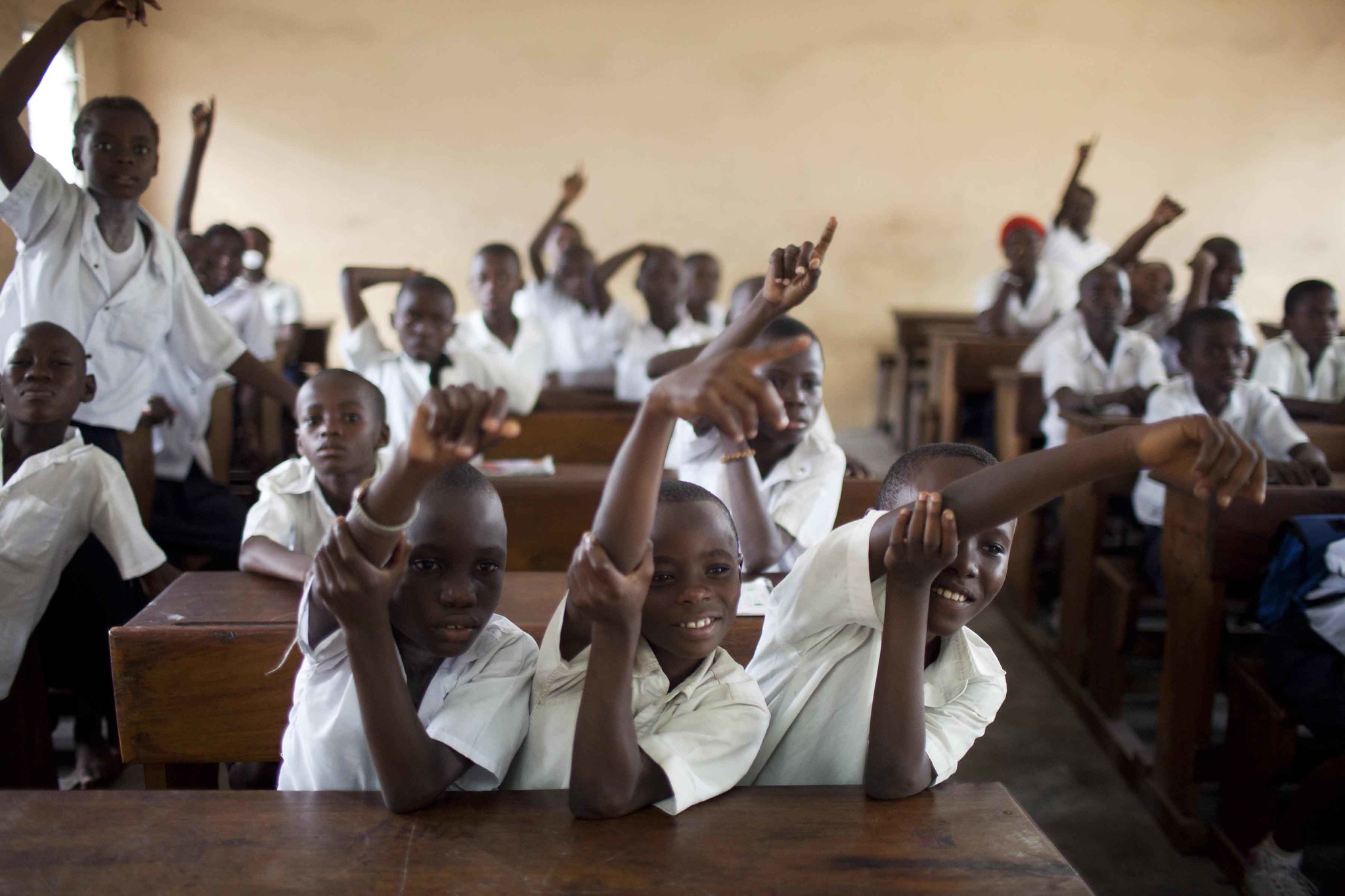 .  ​Students raise their hands to answer a class questions at the St. Louis Primary School in Kinshasa