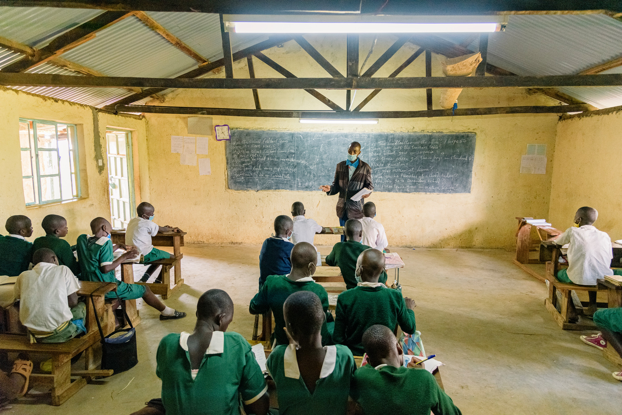a classroom in Kenya with a teacher speaking to his student