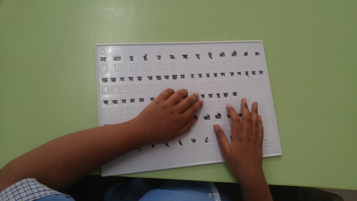 In India, a learner who is blind uses braille stimuli on a Marathi reading assessment.