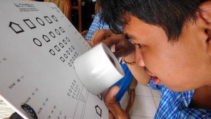 A child with a hearing impairment undergoes a low vision assessment in Cambodia. 